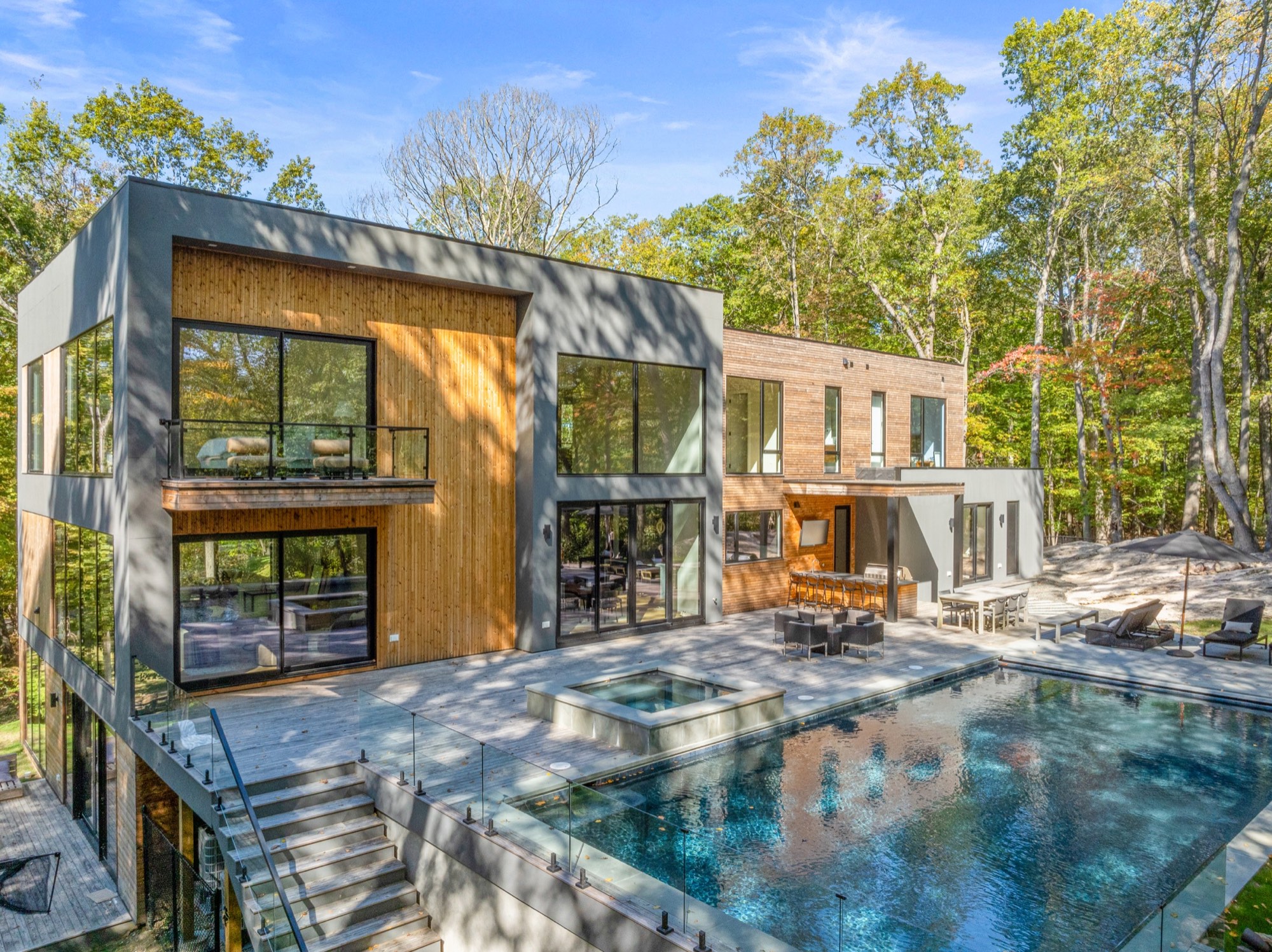 Edgar Road, Greenwich, CT: a cedar and charcoal residence opening onto a pool terrace among tall trees